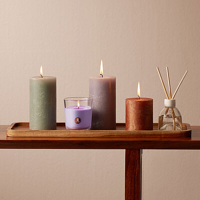 Fein arrangiertes Geschenk-Set mit mehreren Rustik-Kerzen – elegante Stumpen- und Duftkerzen in harmonischer Farbpalette, stilvoll auf Holztablett inszeniert und ideal als stimmungsvolles Kerzen‑Geschenkset.