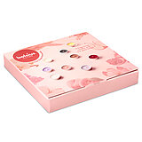 Eine rosafarbene Geschenkbox von Bolsius mit bunten Duft-Teelichtern und einem Teelichtglas.