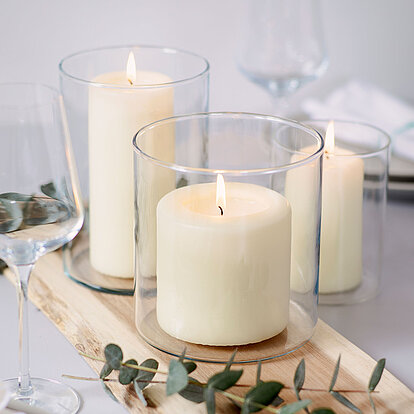 Schlichte Eleganz für den gedeckten Tisch: Die Bolsius Professional Stumpenkerzen in Elfenbein sorgen für ein warmes, ruhiges Licht und harmonieren perfekt mit modernen Glaswindlichtern und natürlicher Dekoration.
