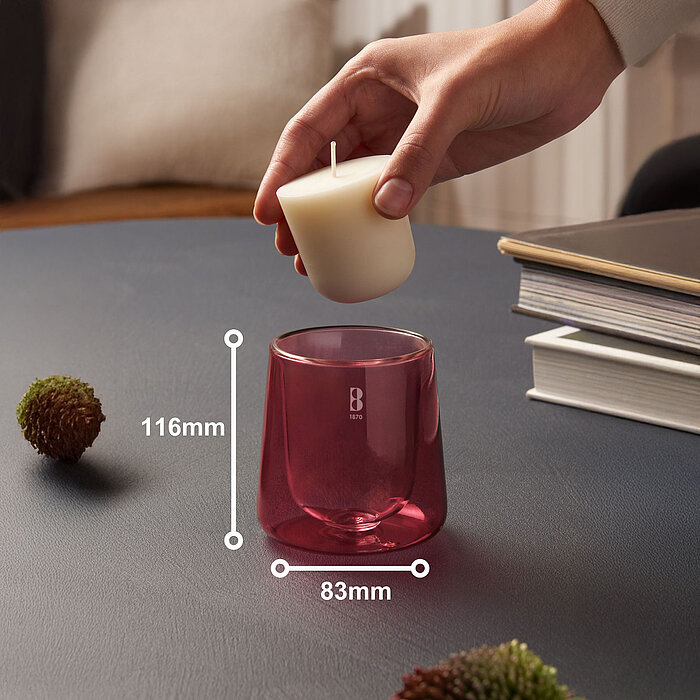 Eine Hand bestückt ein pinkes Bolsius Cleanlight Duftglas mit einem Nachfüller mit Zedernholz und Vetiver-Duft.