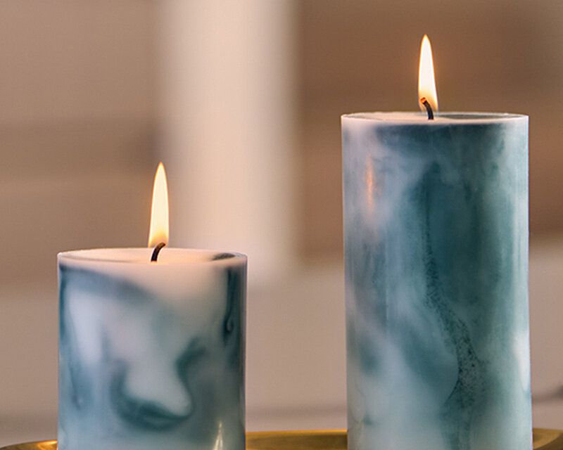 Bolsius Marble Kollektion Stumpenkerzen in Malachit-Grün, bestehend aus einer 80/68 und einer 130/68 Kerze. Die beiden handgefertigten Kerzen mit ihrem einzigartigen Marmor-Look sind brennend auf einem goldenen Tablett arrangiert und schaffen eine stilvolle, gemütliche Atmosphäre